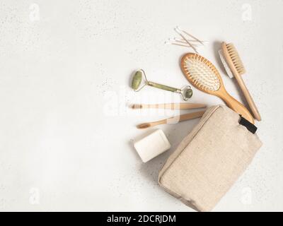 Borsa cosmetica ecologica con un set di articoli per la cura e l'igiene delle donne. Spazzolino da bambù, pettine, massaggiatore di cristallo, spazzola di pietra pomice, bastoncini di cotone An Foto Stock