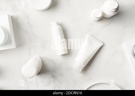 Vista dall'alto dei tubi con prodotti di bellezza in marmo tavolo in bagno Foto Stock