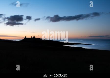 Una notte di fine estate in Northumberland che guarda a nord sul castello di Dunstanburgh. Foto Stock