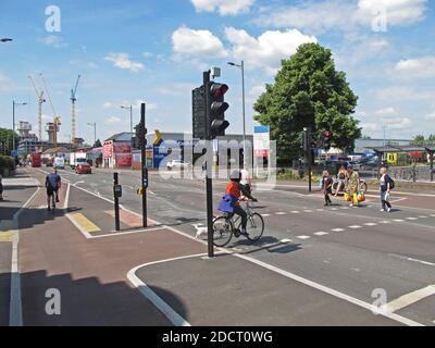 I ciclisti e i pedoni utilizzano un nuovo passaggio separato su Lea Bridge Road, Londra, Regno Unito. Parte del programma Mini Holland di Waltham Forest per la bicicletta più sicura Foto Stock