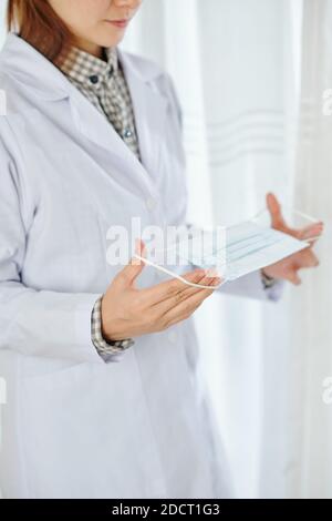Medico indossando maschera medica Foto Stock