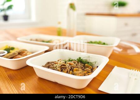 Primo piano di contenitori con una sana cena pronta con tagliatelle, cozze e micrograni sul tavolo. Foto Stock