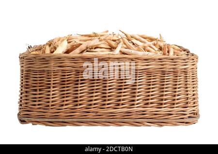 Cialde di fagioli asciutte in un cesto di vimini su sfondo bianco, isolate, organiche Foto Stock
