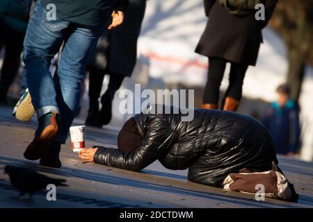 Amburgo, Germania. 23 Nov 2020. Profondamente piegata, una donna si inginocchia su un sentiero su Jungfernstieg tra i passanti e chiede denaro. Credit: Christian Charisius/dpa/Alamy Live News Foto Stock