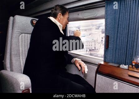 Ex Presidente degli Stati Uniti Ronald Reagan onde da Nighthawk 1 come egli prende un'ultima gita aerea di Washington DC, prima di rientrare a casa per la California il giorno dell'inaugurazione, 20 gennaio 1989. L'elicottero ha volato dalla motivazione del Campidoglio degli Stati Uniti alla Andrews Air Force Base. In fondo è il Campidoglio US. Un elicottero marino che ha il presidente di seduta a bordo utilizza il segno di chiamata "marine". In questo caso, poiché il sig. Reagan non era più la seduta il Presidente dell'elicottero era conosciuto dal segnale di chiamata 'Nighthawk 1' per il Marine Helicopter Squadron One (HMX-1), soprannominato il "Nighthawks. Foto Stock