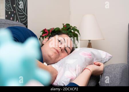 Primo piano di messa a fuoco selettiva della donna malata che dorme sul divano a. casa con covid19 sars virus influenza falsa replica plastica Foto Stock