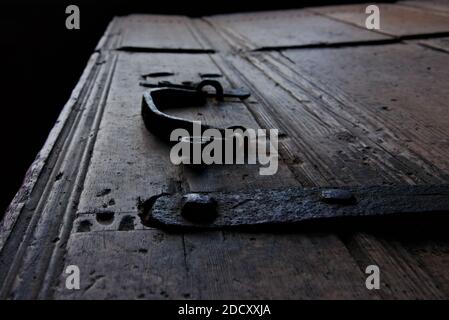 Primo piano di vecchio petto di legno d'epoca usurato con vecchie cerniere in ghisa arrugginite e manico. Foto Stock