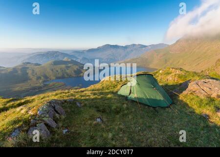 Wildcamping sito con tenda che si affaccia Stickle Tarn nel Distretto Inglese Lago in una mattinata soleggiata. Foto Stock