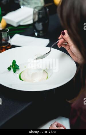 dessert al cocco con sorbetto, dessert gourmet su un piatto bianco in un ristorante. Foto Stock