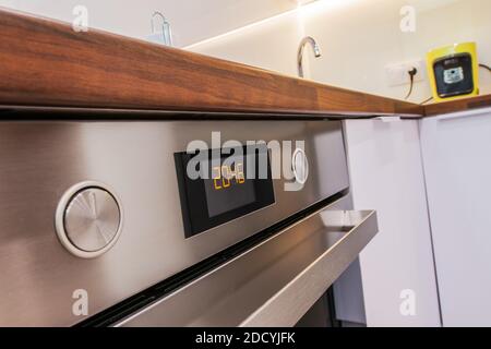 Tema elettrodomestici. Forno da cucina moderno in acciaio inox con cifre arancioni Timer primo piano. Tema cucina. Foto Stock