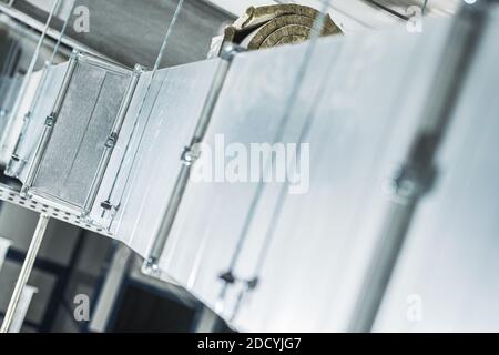 Chiusura del condotto dell'aria in metallo HVAC dell'edificio del magazzino. Tecnologie di circolazione dell'aria. Foto Stock