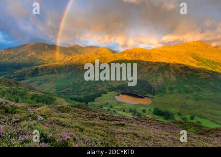 Incredibile doppio arcobaleno sulla valle di Cumbrian con spettacolari nuvole e luce del mattino presto. Foto Stock