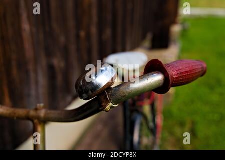 Primo piano di campana in acciaio e manubrio su una classica bicicletta d'epoca senza persone nell'immagine. Foto Stock