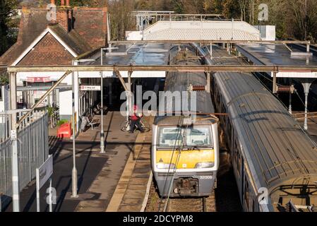 Stazione ferroviaria di Prittlewell, Southend, Essex, Regno Unito. Greater Anglia linea da Southend Victoria a Liverpool Street linea. Treni che passano. Il ciclista si allontina Foto Stock