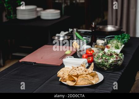 tavolo con prodotti per tacos. Lo chef del ristorante preparerà i tacos piccanti di gamberi con Coleslaw e salsa di fronte ai clienti. Foto Stock