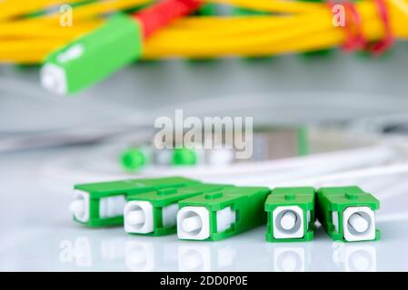 I connettori in fibra ottica si trovano in primo piano e il telaio di distribuzione in background Foto Stock