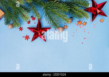 Ramificazione di abete rosso e decorazione di Natale rossa su sfondo blu Foto Stock