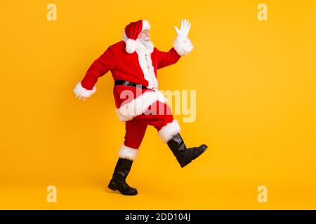 Vista laterale del suo profilo HE a lunghezza intera Bella divertente anziano spesso Santa San Nicola capelli bianchi andando avere divertimento che rende la vendita di fase isolata Foto Stock