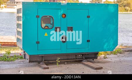 Big Diesel Power Stand by Generator at River Coast Foto Stock