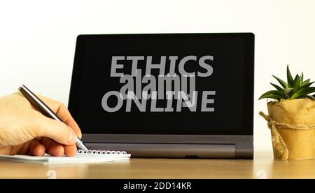 Etica online. Tablet con etica delle parole online. Mano maschio con penna, pianta della casa. Spazio di copia. Business ed etica online concetto. Foto Stock