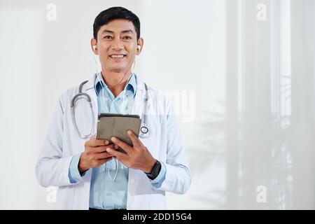 Medico di mezza età che effettua una videochiamata Foto Stock