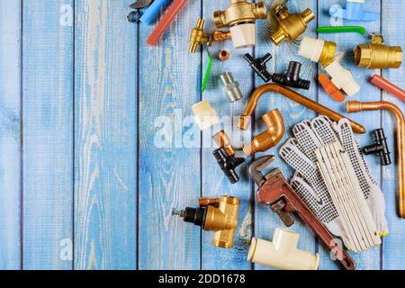 Kit di alimentazione acqua tubi in polipropilene, angoli in plastica, chiave, guanti da lavoro su parti idrauliche, accessori Foto Stock