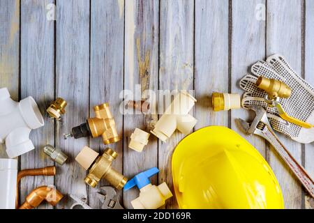 Utensili idraulici riparazione attrezzature bagno gli accessori sono di costruzione diversa su tavolo di lavoro in legno. Foto Stock