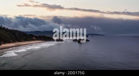 Cannon Beach, Oregon, Stati Uniti. Splendida vista panoramica aerea della costa rocciosa dell'Oceano Pacifico. Cielo drammatico dell'alba nuvoloso. Foto Stock