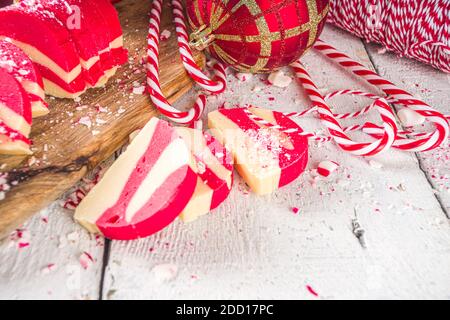 Biscotti fatti in casa alla menta piperita, salame di cioccolato in velluto bianco e rosso con biscotti e nocciole. Dolci natalizi in stile caramella Foto Stock