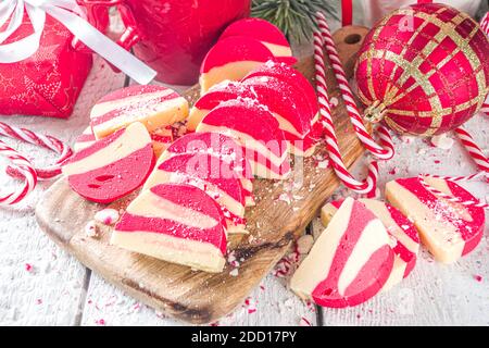 Biscotti fatti in casa alla menta piperita, salame di cioccolato in velluto bianco e rosso con biscotti e nocciole. Dolci natalizi in stile caramella Foto Stock