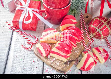 Biscotti fatti in casa alla menta piperita, salame di cioccolato in velluto bianco e rosso con biscotti e nocciole. Dolci natalizi in stile caramella Foto Stock