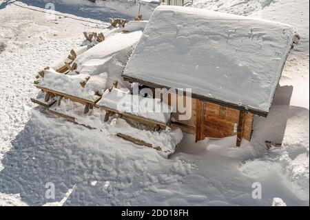 Piccola casa in legno coperta di neve nella natura invernale. Ghiacciai, Diablerets in Svizzera. Tranquillità, Foto Stock