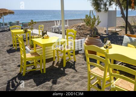 Santorini, Grecia - 17 settembre 2020: Tavoli in ristorante alla Spiaggia Nera a Perissa, una città sull'isola di Santorini. CICLADI, Grecia Foto Stock