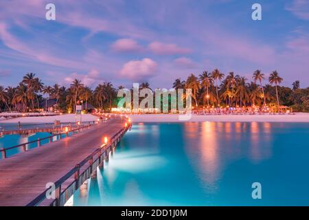 Un tramonto meraviglioso cielo e riflessione sul mare calmo, Maldive spiaggia paesaggio di lusso oltre i bungalow sull'acqua. Scenario esotico di vacanze estive e vacanze Foto Stock