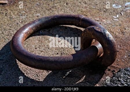 Grande anello di ferro arrugginito utilizzato per ormeggiare le navi nel porto. Foto Stock