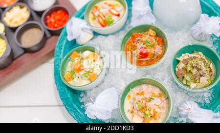 Ceviche gourmet frutti di mare su tavola bianca. Deliziose ceviche di gamberi con verdure, spezie e lime da vicino su un piatto. Lussuoso ristorante all'aperto Foto Stock
