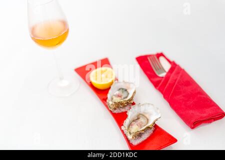 Ostriche fresche primo piano su piatto blu, servito tavolo con ostriche, limone e ghiaccio. Cibo di mare sano. Cena Oyster fresca nel ristorante. Cibo gourmet. Foto Stock
