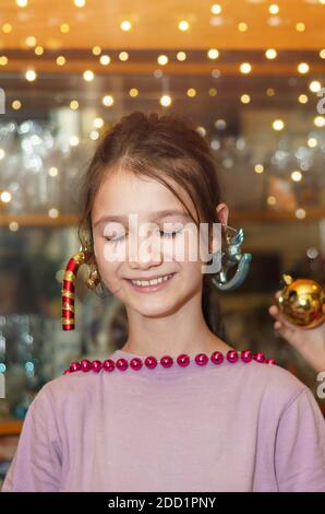 Ritratto di una bambina con occhi chiusi e un Un sorriso sognante in attesa di Natale Foto Stock