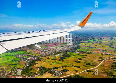 MANILA, FILIPPINE - 23 FEBBRAIO 2013: L'aereo Cebu Pacific ala sopra i sobborghi della città di Manila nelle Filippine Foto Stock