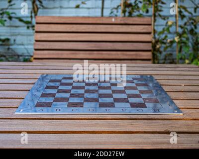 Una scacchiera nel parco. Una panchina di legno e un tavolo da scacchi nel parco. Foto Stock