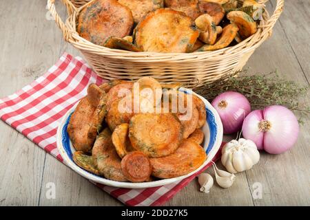 Cappelli di latte di zafferano o funghi di pino rosso in cestini e. ciotole sul tavolo da cucina Foto Stock