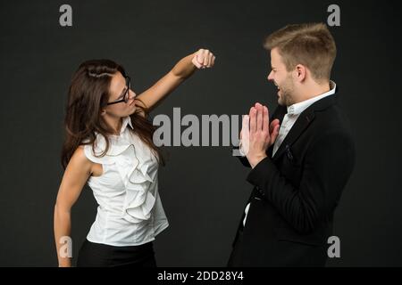 Confronto con la forza. Donna arrabbiata lancio punch a collega maschio. Conflitto sul luogo di lavoro. Relazioni impegnative. Lotta per il potere e il favore. Relazioni e relazioni. Comunicazione aziendale. Foto Stock