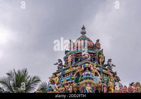 Kadirampura, Karnataka, India - 4 novembre 2013: Tempio di Sri Murugan. Statue colorate sul pinnacolo del gopuram contro il paesaggio nuvoloso grigio. Foto Stock