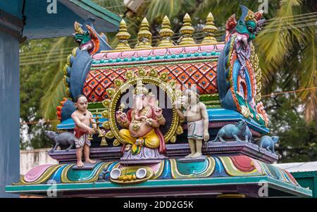 Kadirampura, Karnataka, India - 4 novembre 2013: Tempio di Sri Murugan. Colorata statua di Ganesha onorata da servitori che gli portano il cibo. Indietro Foto Stock