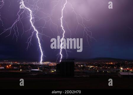 Fulmini diretti dai cieli tempestosi sul paesaggio urbano. Foto Stock