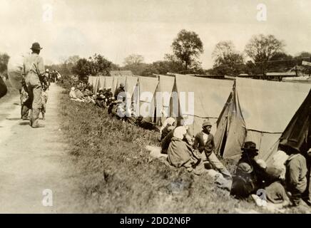 Lavori di soccorso del Mississippi tempo di crepuscolo, nella levée di Greenville, Mississippi, dove l'unico rifugio disponibile è una tenda, fornita dalla Croce Rossa. La fotografia mostra gli afroamericani in un campo tenda a seguito dell'alluvione del Grande fiume Mississippi del 1927. Foto Stock