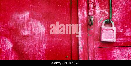 Lucente lucchetto rosa appeso alla porta del garage arrugginita. Sbloccare dati, informazioni sicure. Amore e concetto di relazione. Foto Stock