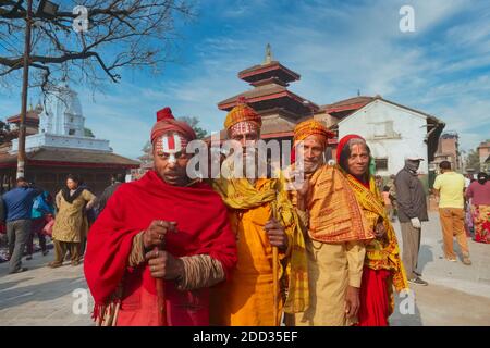 Un gruppo motley di sadhus (uomini indù santi, ascetici) e un sadhvi (l'equivalente femminile) in posa in piazza Durbar, Kathmandu, Nepal Foto Stock