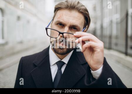 Un uomo d'affari che indossa occhiali all'aperto Foto Stock