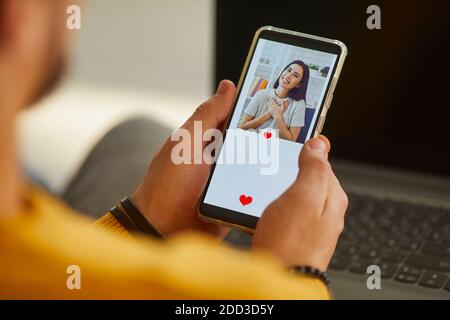 Uomo singolo guardando la bella foto del profilo della giovane donna sopra applicazione di datazione e pressione come Foto Stock